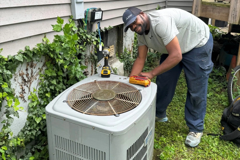 Schmidt Heating and Cooling HVAC technician performing AC repair on an outdoor unit